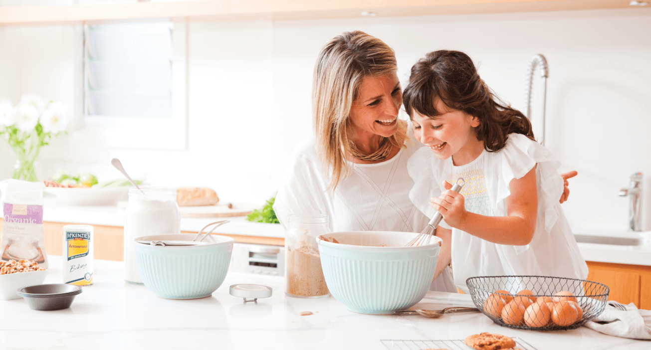 woman and daughter happily baking in the kitchen